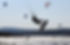 Kitesurfer catching air with a jump over the water