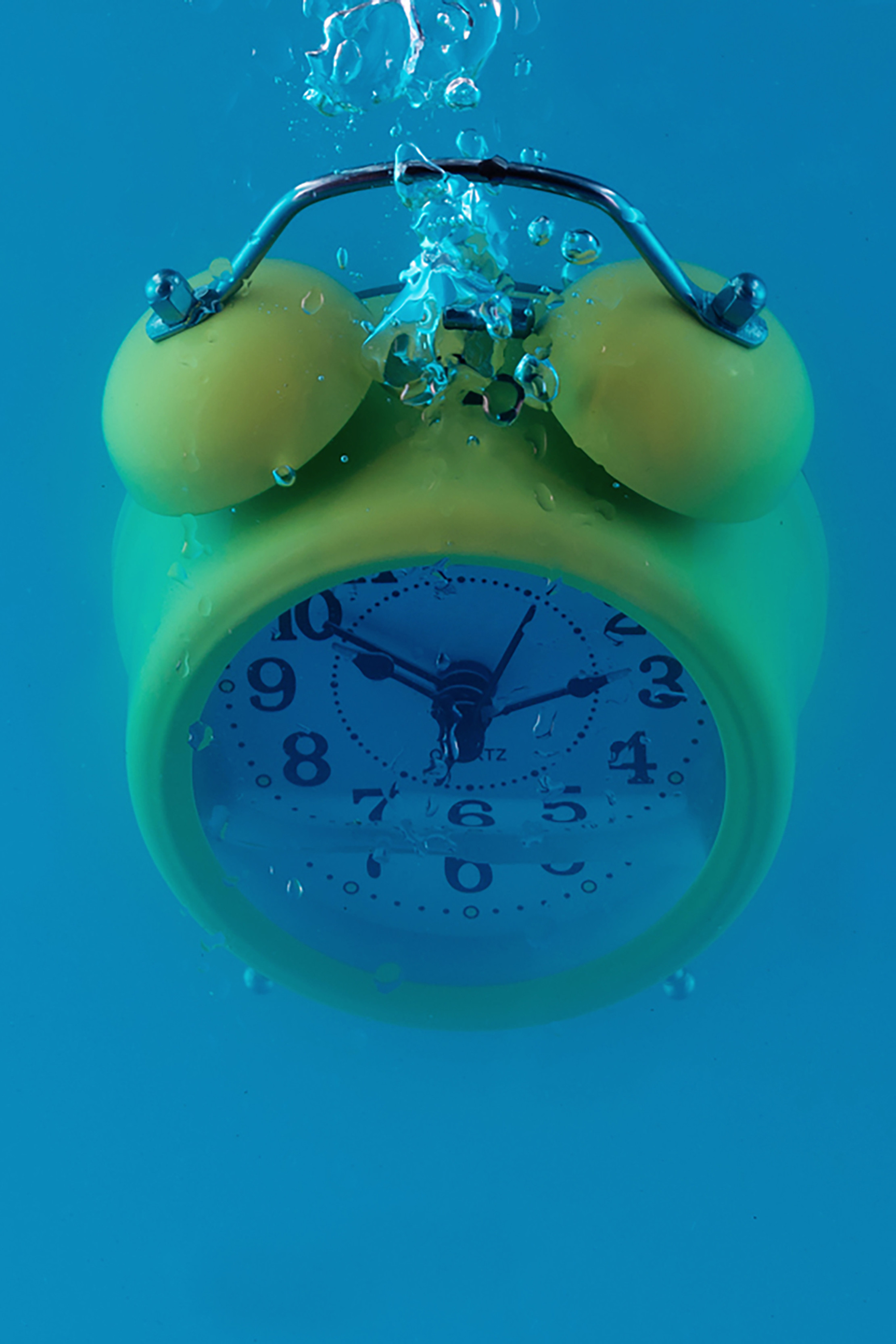 yellow old fashioned alarm clock underwater
