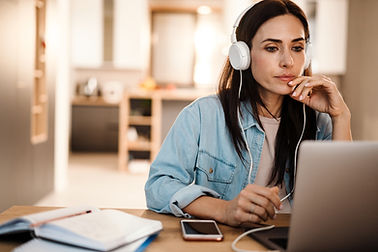 Person sitting at a desk in front of a computer, engaging in an online workshop