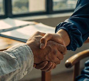 Handshake between dark skinned man and white woman with long sleeved shirts on