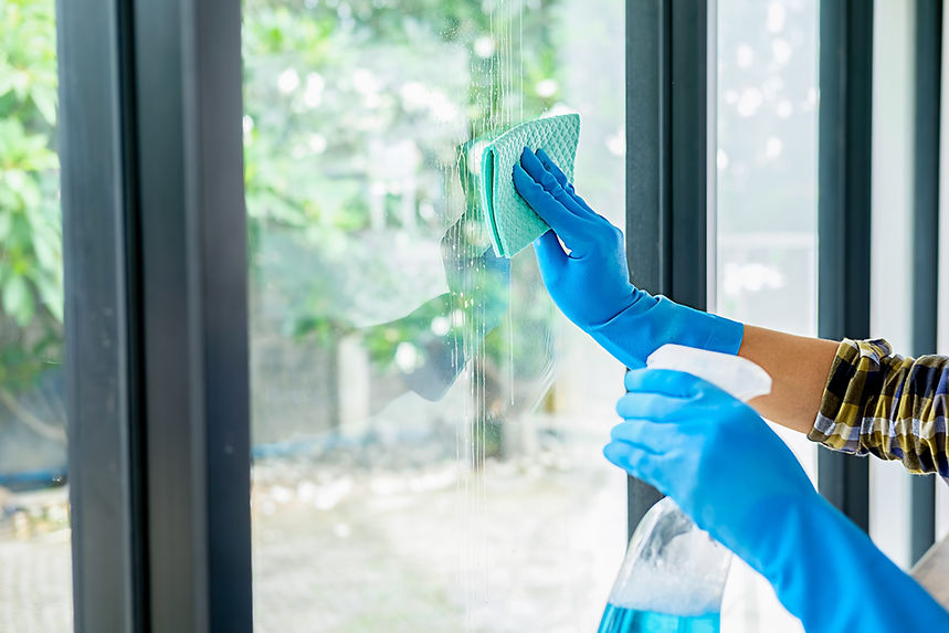 gloved hands cleaning windows