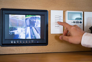 A person pushing buttons for a security surveillance system at home