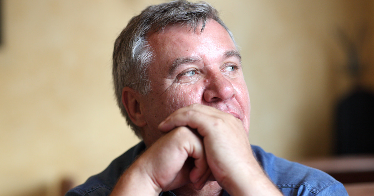 A person sitting quietly with one hand on their chest, looking thoughtful and calm, in soft natural light.