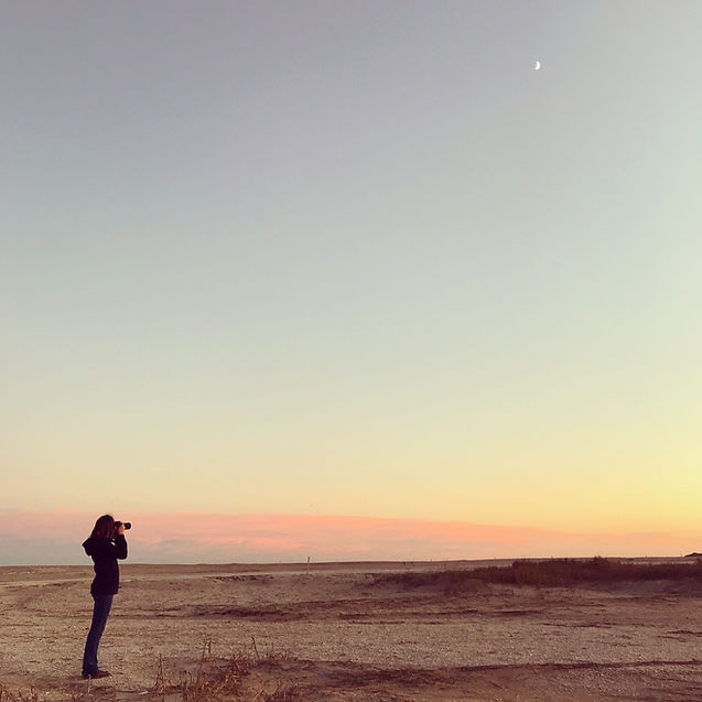 Woman photographing sunset