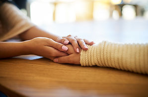 Closeup shot of two people holding hands in comfort