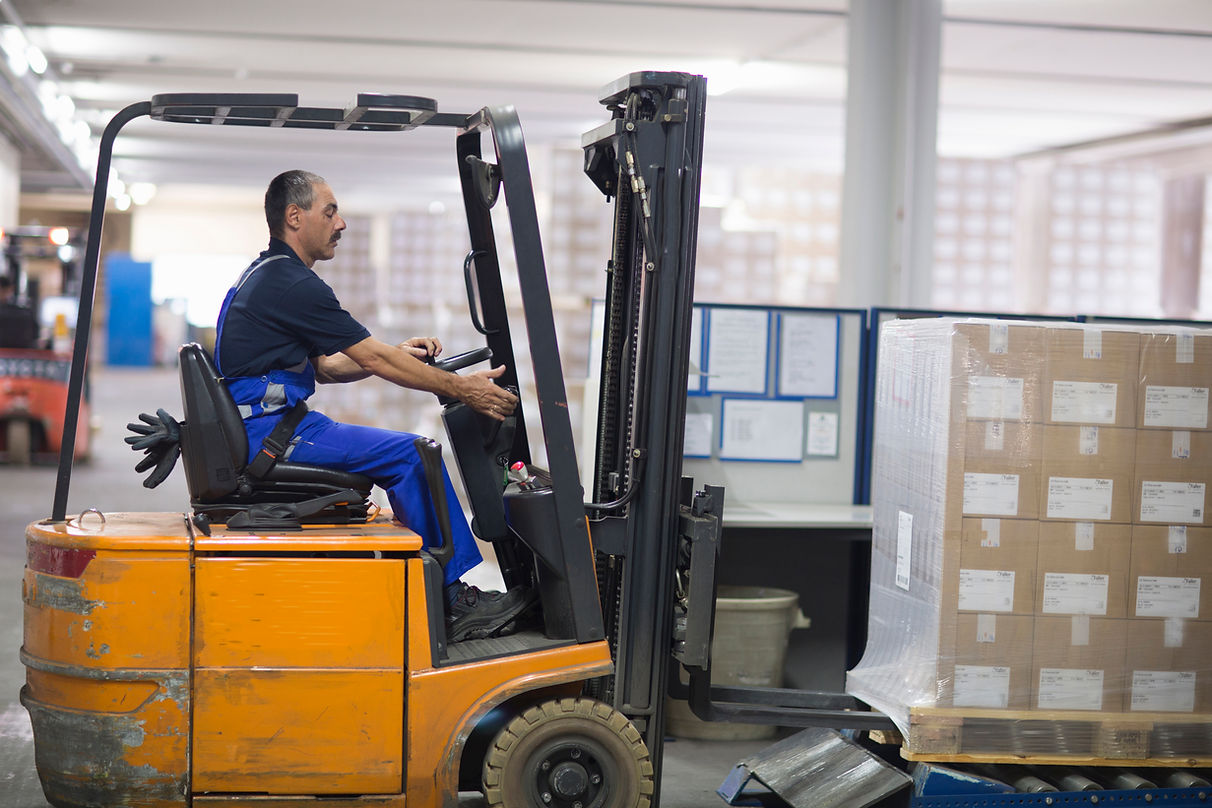 man using forklift truck in factory