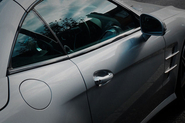 Close up side view showing the sleek contours and door handle of a polished grey car