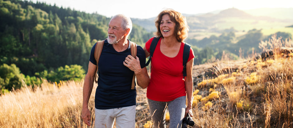 Middle-aged couple enjoying a hike outdoors, promoting healthy bones through exercise