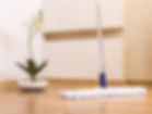 Cleaning a hardwood floor with a soft mopping tool.