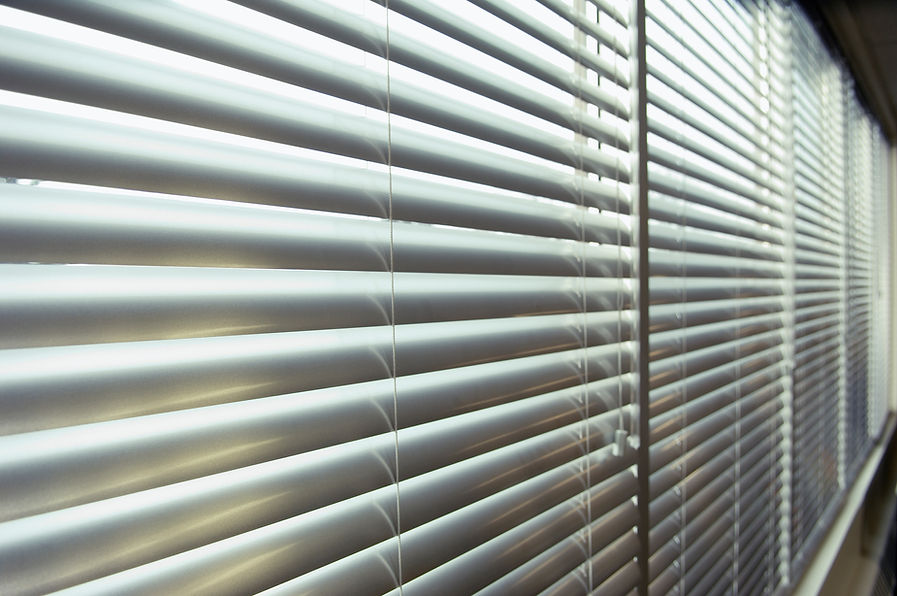 Closed white window blinds with horizontal slats