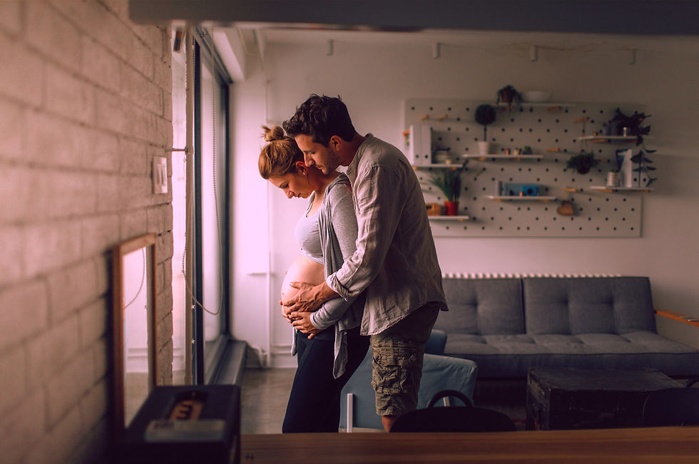 A couple embracing a growing baby bump in their home