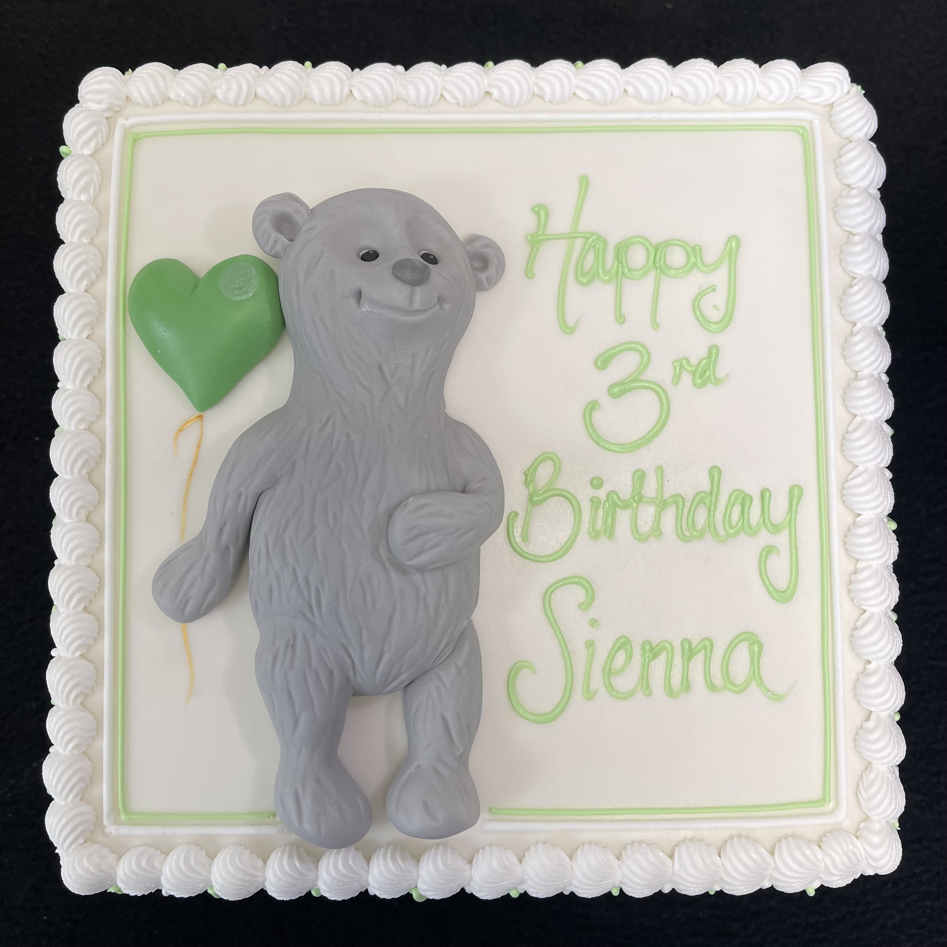 Adorable grey bear-shaped cake with a festive balloon decoration for a cute and fun celebration in UK. Perfect for birthday parties and special occasions.
