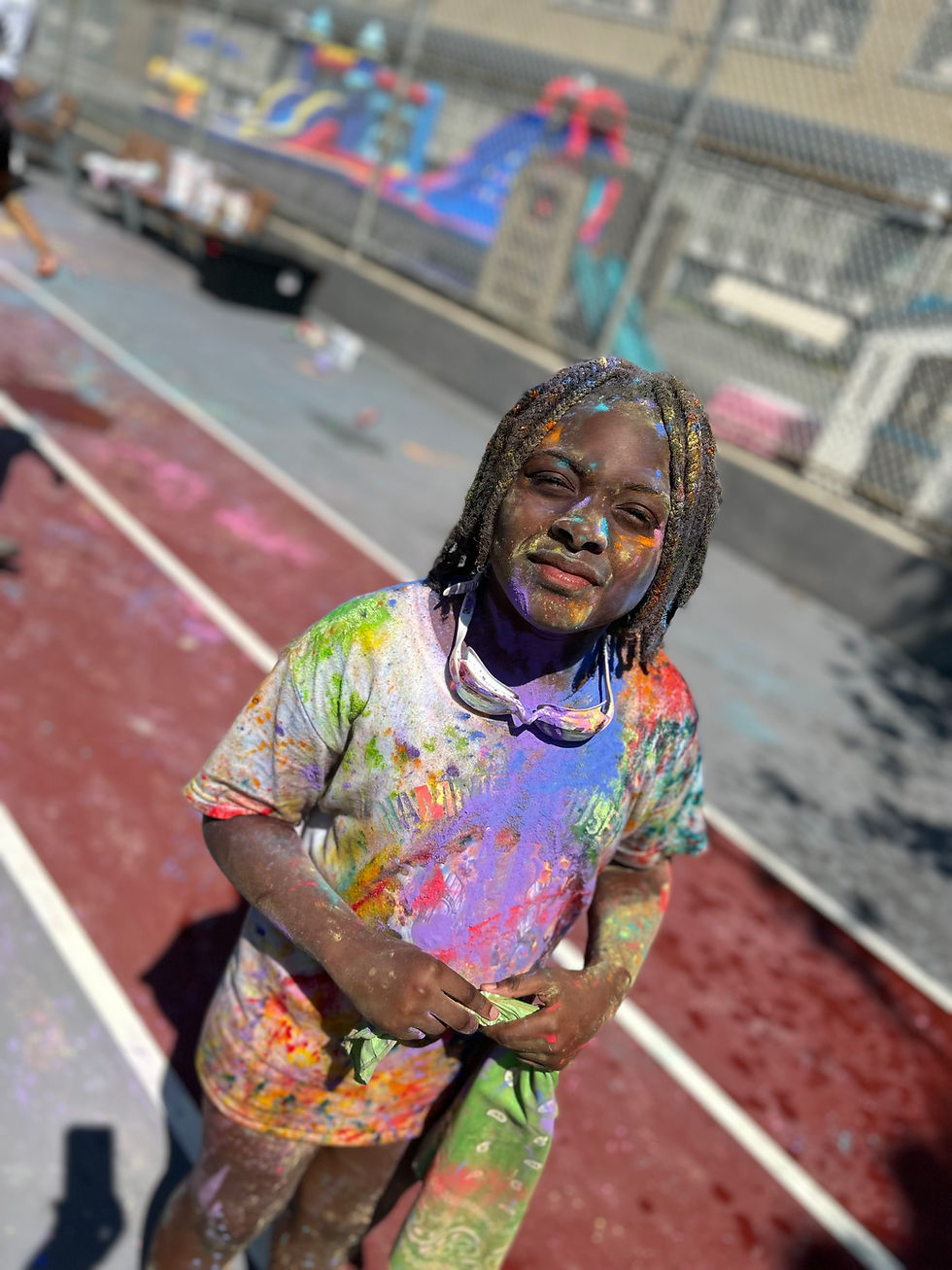 A middle school-age camper is covered in color for Hammel Houses' color run