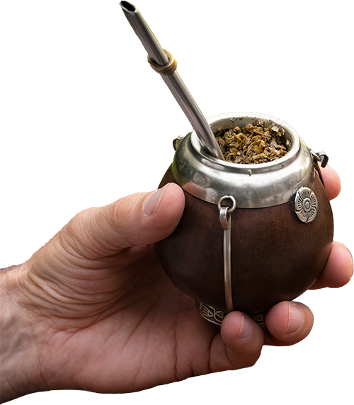 Eye-level view of a kettle pouring hot water into a yerba mate gourd