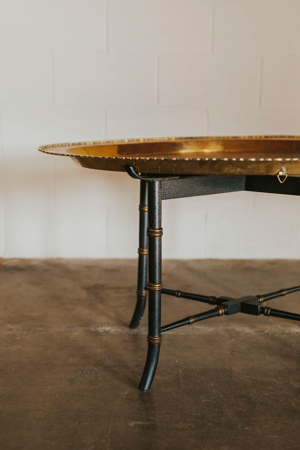 Thumbnail: Ornate brass top table with black, gold-accented legs