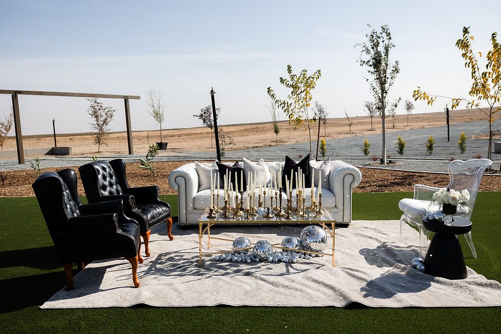 Thumbnail: Outdoor lounge with white sofa, black armchair, and candle-decorated table.
