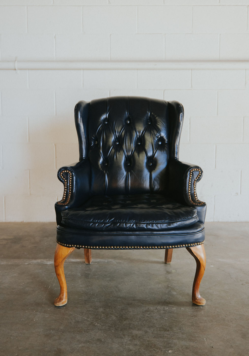 Black tufted leather armchair