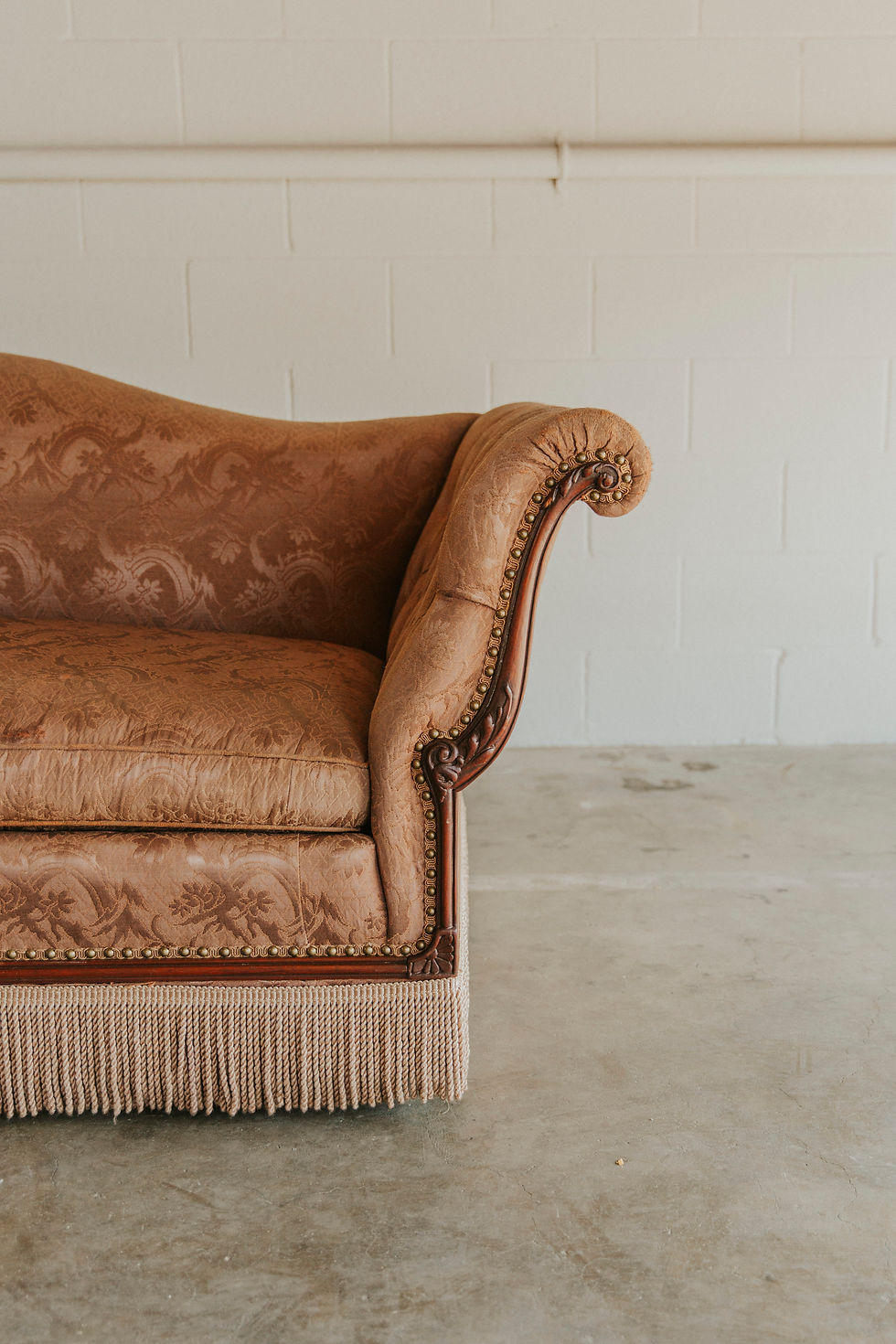Thumbnail: Vintage rust sofa with patterned upholstery and fringe