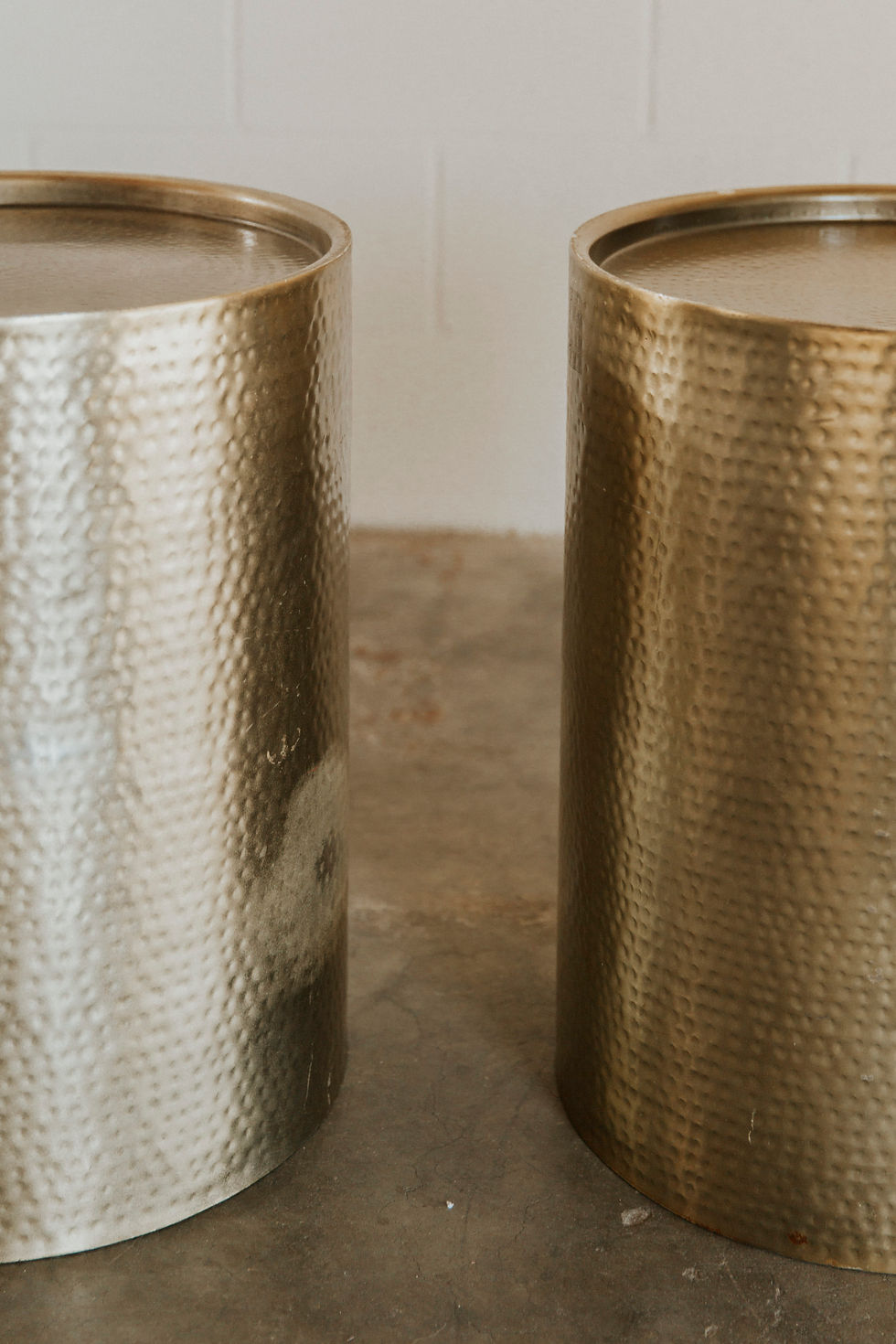 Thumbnail: Two textured metallic cylindrical tables, one silver, one gold