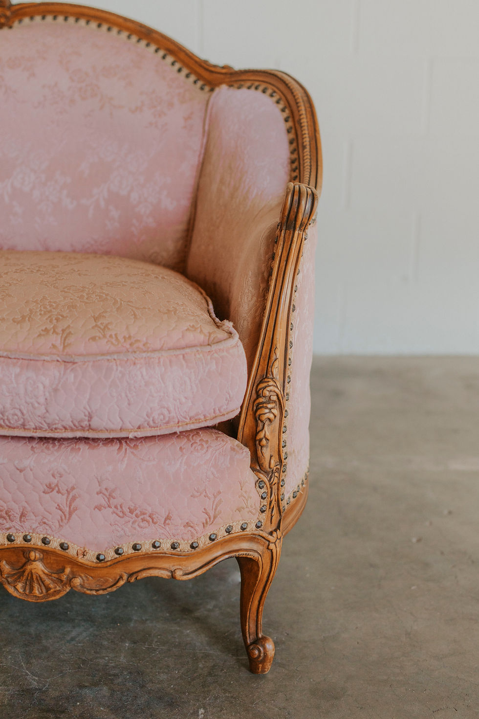 Thumbnail: Vintage pink armchair with carved wooden frame and nailhead trim