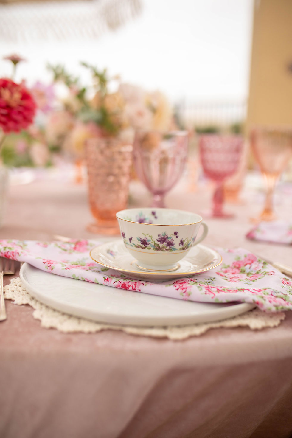 Thumbnail: Tea cup and saucer on a floral napkin at a pink table setting