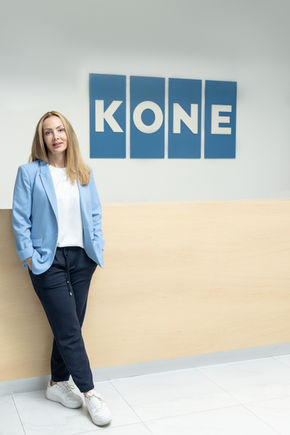 Retrato profesional de mujer frente al logo de empresa, fotografía corporativa natural en locación, tomada por Gonzalo Perea en Ciudad de México