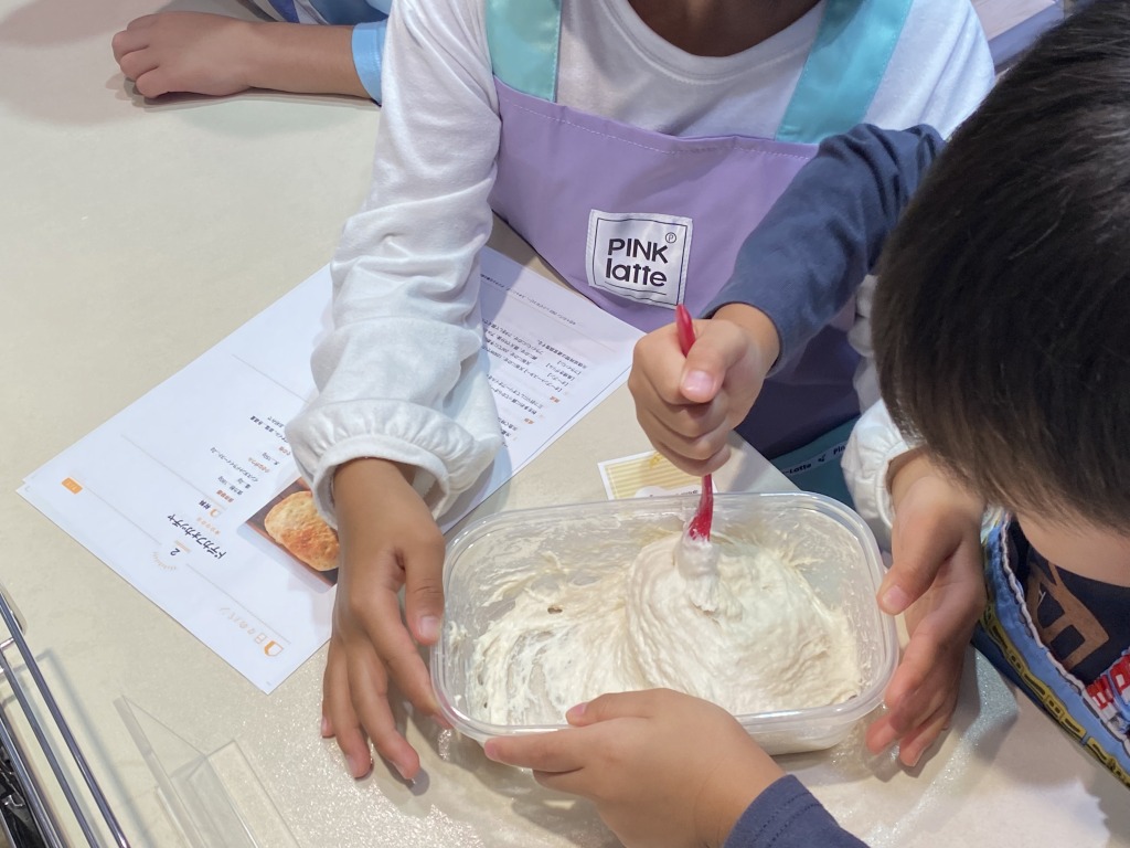 分量を量った強力粉・ドライイースト・塩・水を、タッパーとスプーンを使ってまぜまぜ。