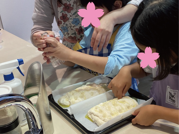 形を作って指で穴をあけて、オリーブオイルをかけて・・・親子で共同作業(*^_^*)オーブンでも焼けますが、トースターやグリルでも焼けるパンなので、オーブンがないお家でも大丈夫!今回はオーブンとリシェルの魚焼きグリルのオーブン機能を使って焼いています。