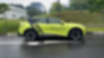 Bright green electric car parked on wet road. Text reads "TOP 5 BEST-SELLING EV BRANDS IN CHINA." Trees and buildings in the background.