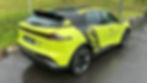 Bright lime EV with black roof on wet road, grass background. "Top 5 Best-Selling EV Brands in China" text, #SpotTheS07ToWin hashtag.