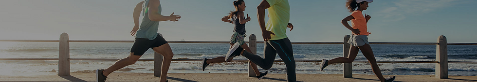 Group of people running near the coast on a sunny day for exercise.