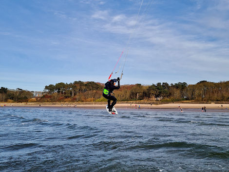 Kitesurfer performing aerial trick over ocean