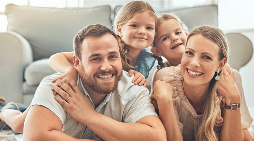 Happy family of four smiling at camera