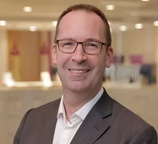Smiling man in suit and glasses