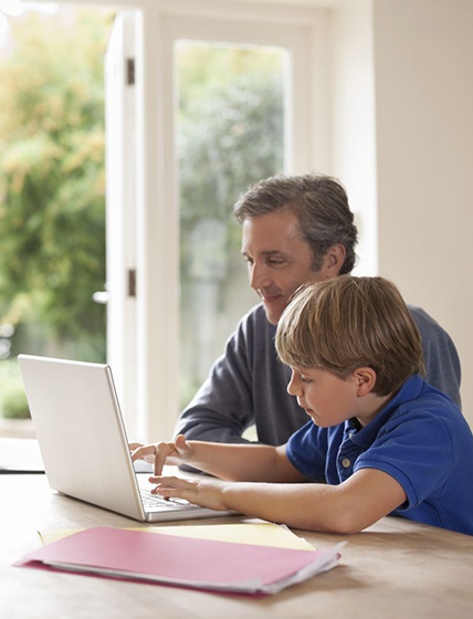 Father and son using laptop together