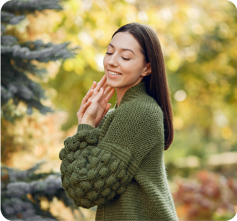 Smiling woman in olive green sweater, autumn park