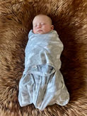 Baby swaddled on a faux fur Yin Mat