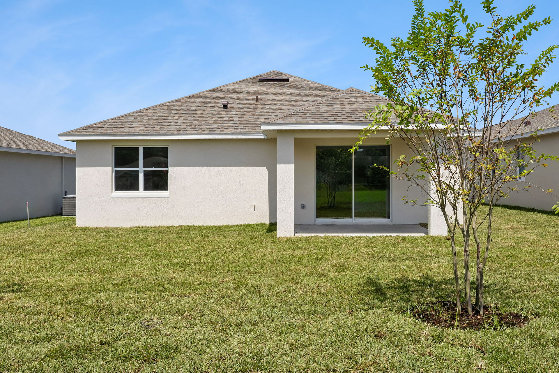 Rear exterior of 3776 Watercliff Circle showing the covered patio, landscaped yard and sliding glass doors