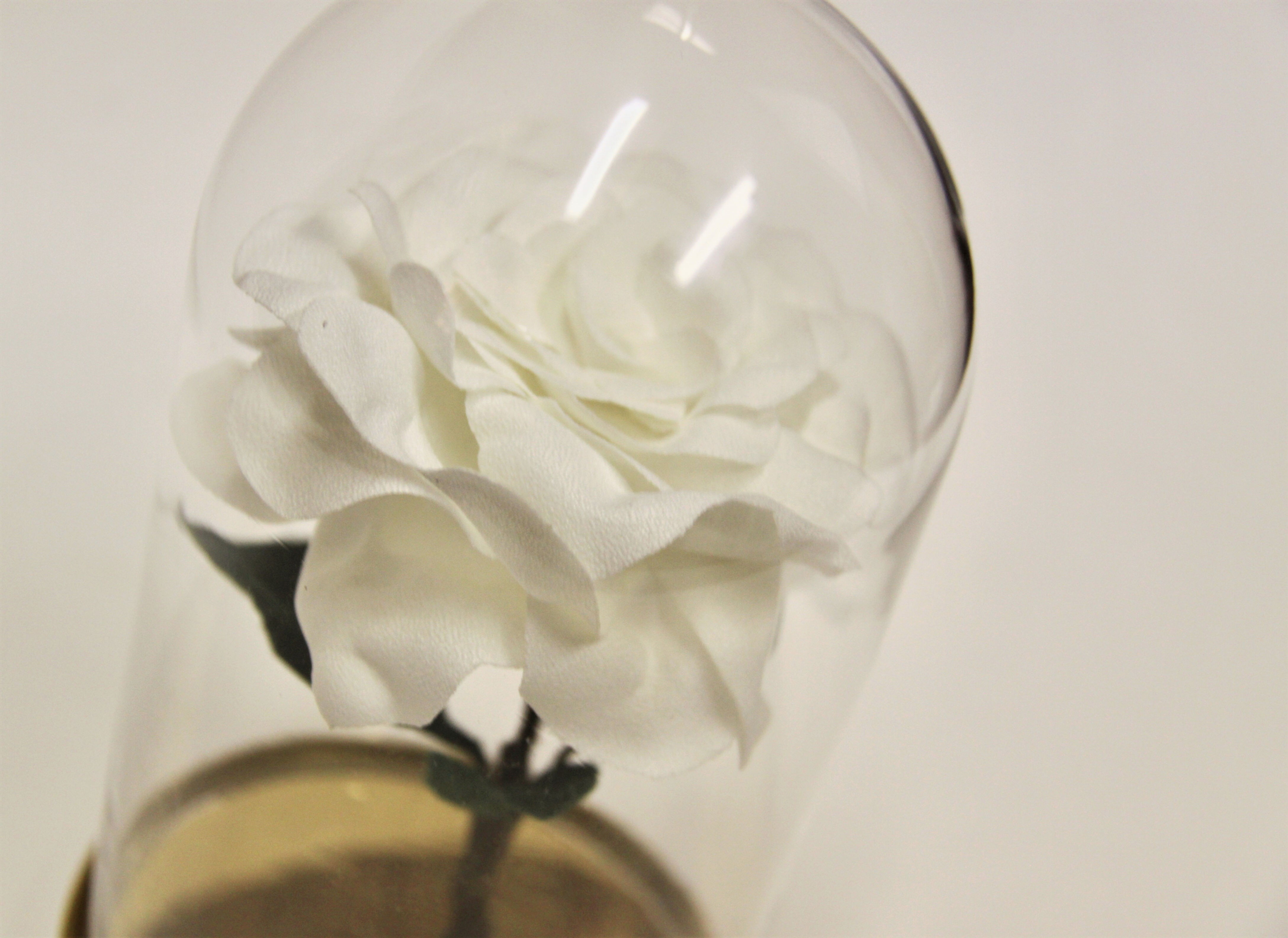 Handsewn floral in a glass bell jar on a weighted gold mirrored base