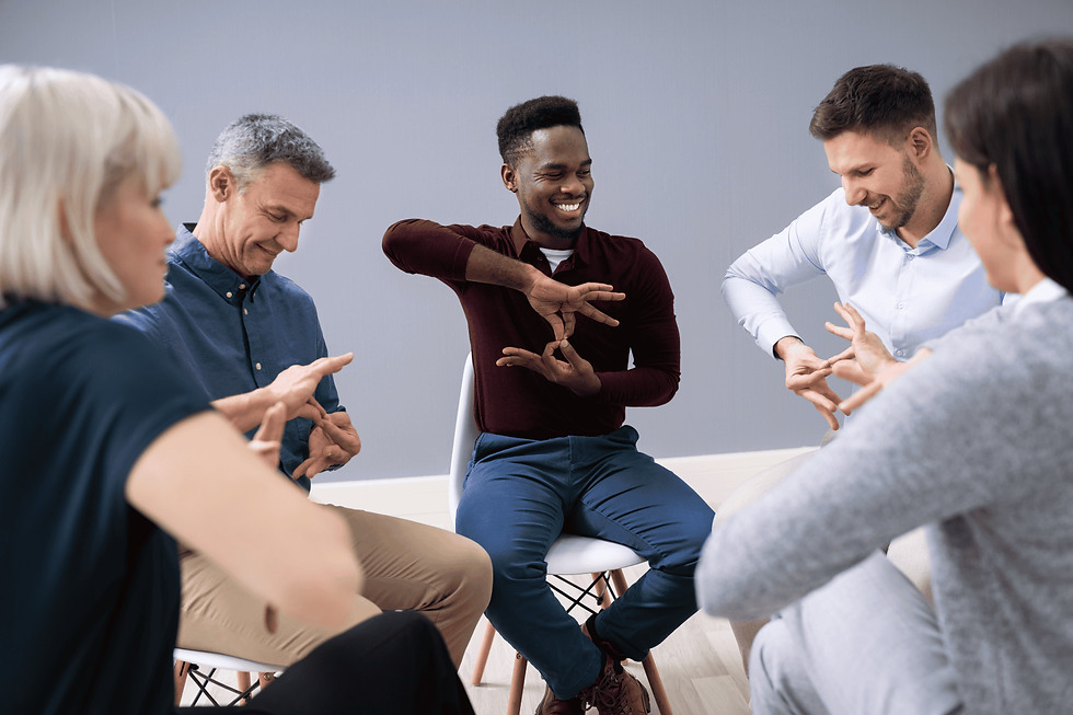 A group of people seated in a circle learning through gestures