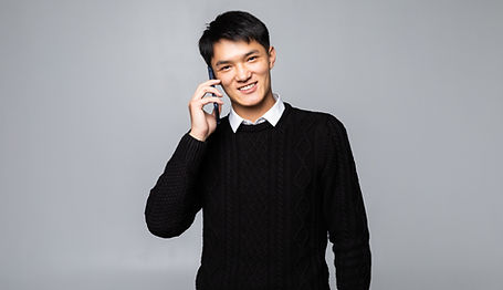 happy-chinese-man-using-smartphone-isolated-against-white-wall.jpg