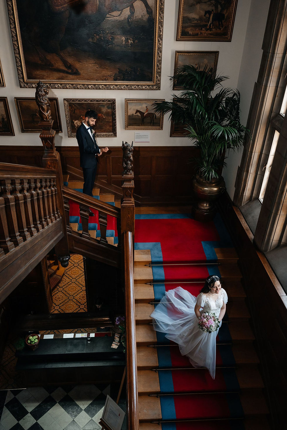 Braut spielt Piano nach der Trauung: Die Braut sitzt am Piano und spielt, während Gäste ihr zuhören, in der beeindruckenden Bibliothek des Schlosshotels Kronberg.