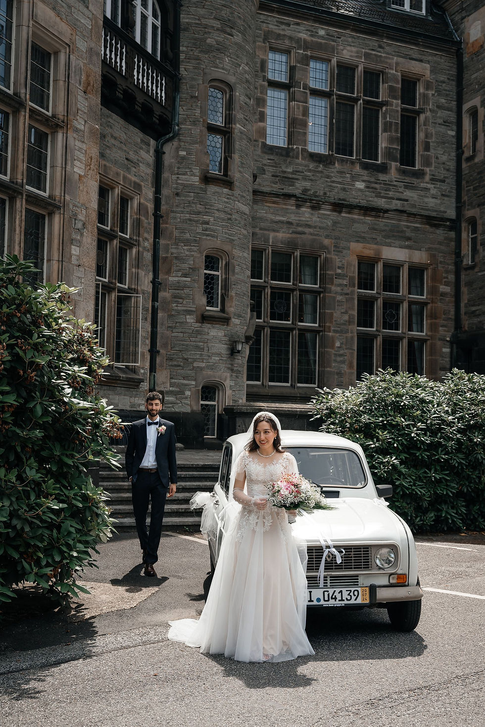 Brautpaar mit Oldtimer vor dem Schloss: Das Brautpaar posiert mit einem nostalgischen Oldtimer vor dem imposanten Schlosshotel Kronberg.