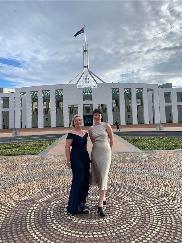 Two women standing in front of Australia's Parliament House