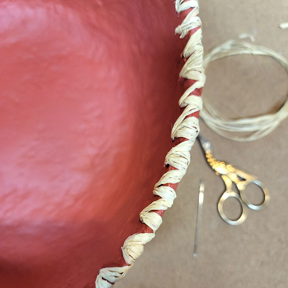 Thumbnail: rust red paper mache bowl with raffia stitched rim