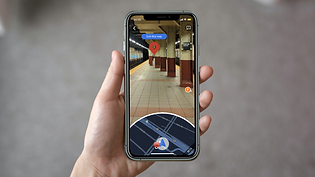 Hand holding iPhone with Google Maps Augmented Reality feature edited for subway navigation