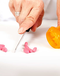 Pharmacist cutting pills