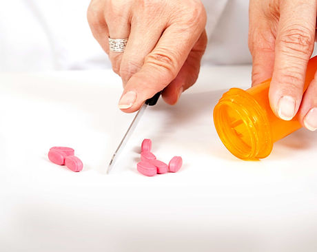 Pharmacist cutting pills