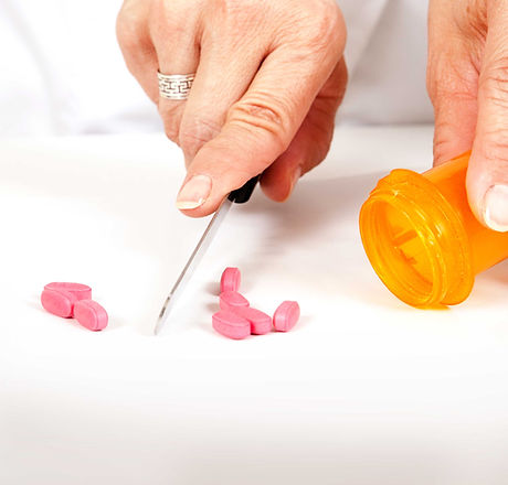 Pharmacist cutting pills