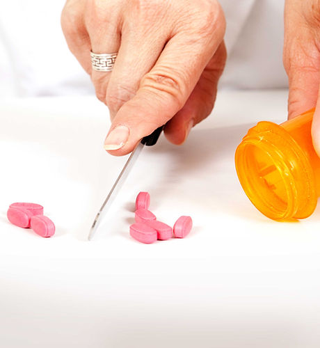 Pharmacist cutting pills